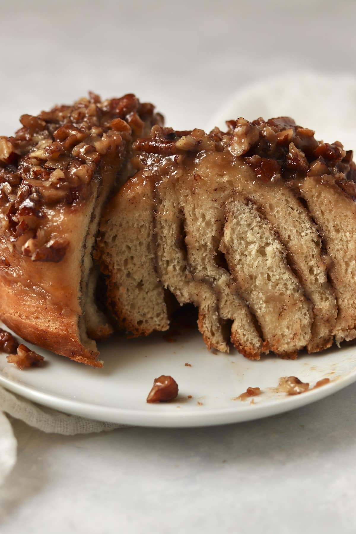 Close up of a halved sticky bun on a plate.