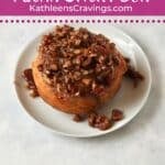 Single serve sticky bun with pecans on a plate.