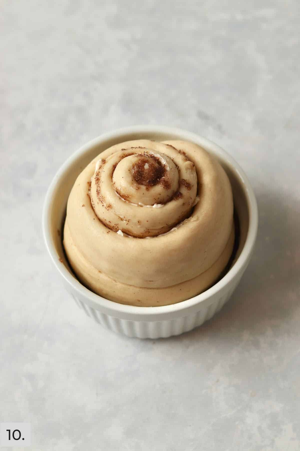 Single pecan sticky bun in a ramekin after rising and before baking.