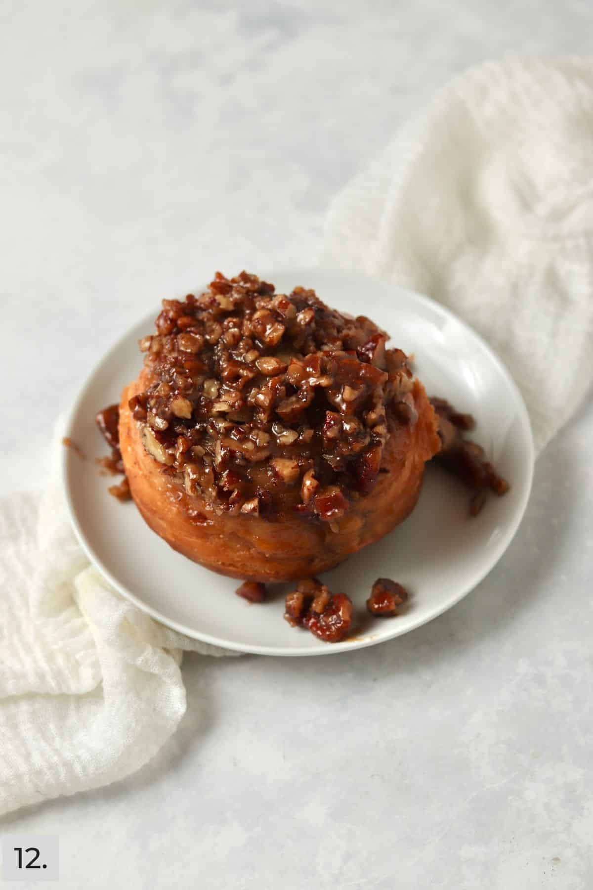 Baked pecan sticky bun inverted onto plate.