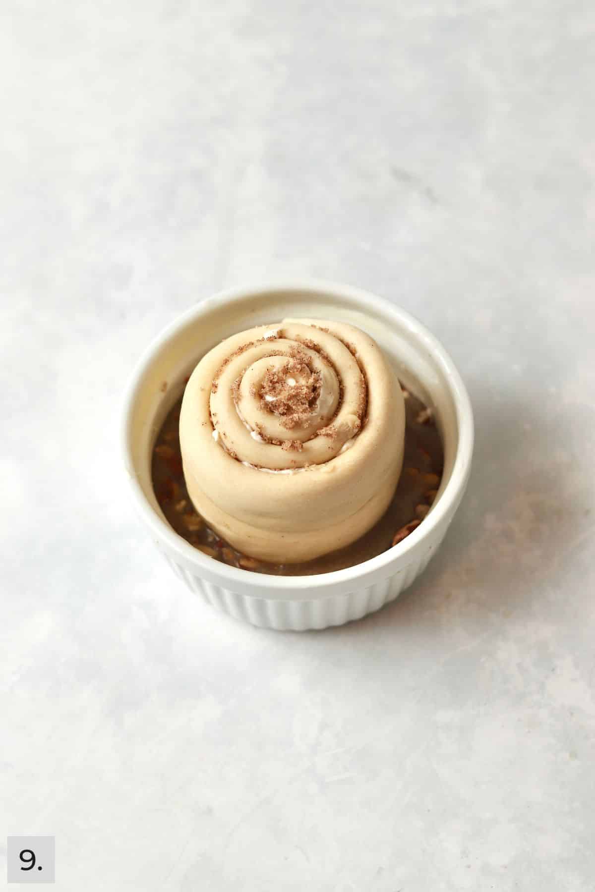Pecan sticky bun in a ramekin before proofing.
