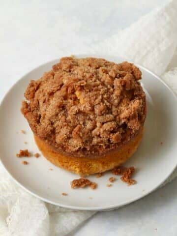 Single serve pumpkin coffee cake with streusel on a plate.
