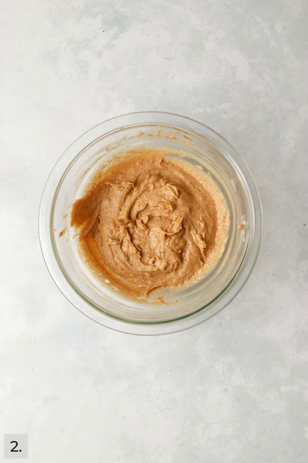 Pumpkin muffin batter in a mixing bowl.
