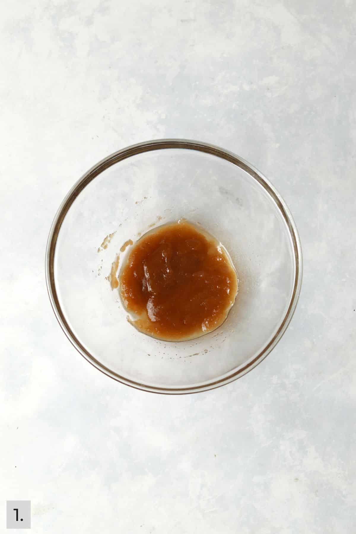 Melted butter mixed with brown sugar in a small bowl.