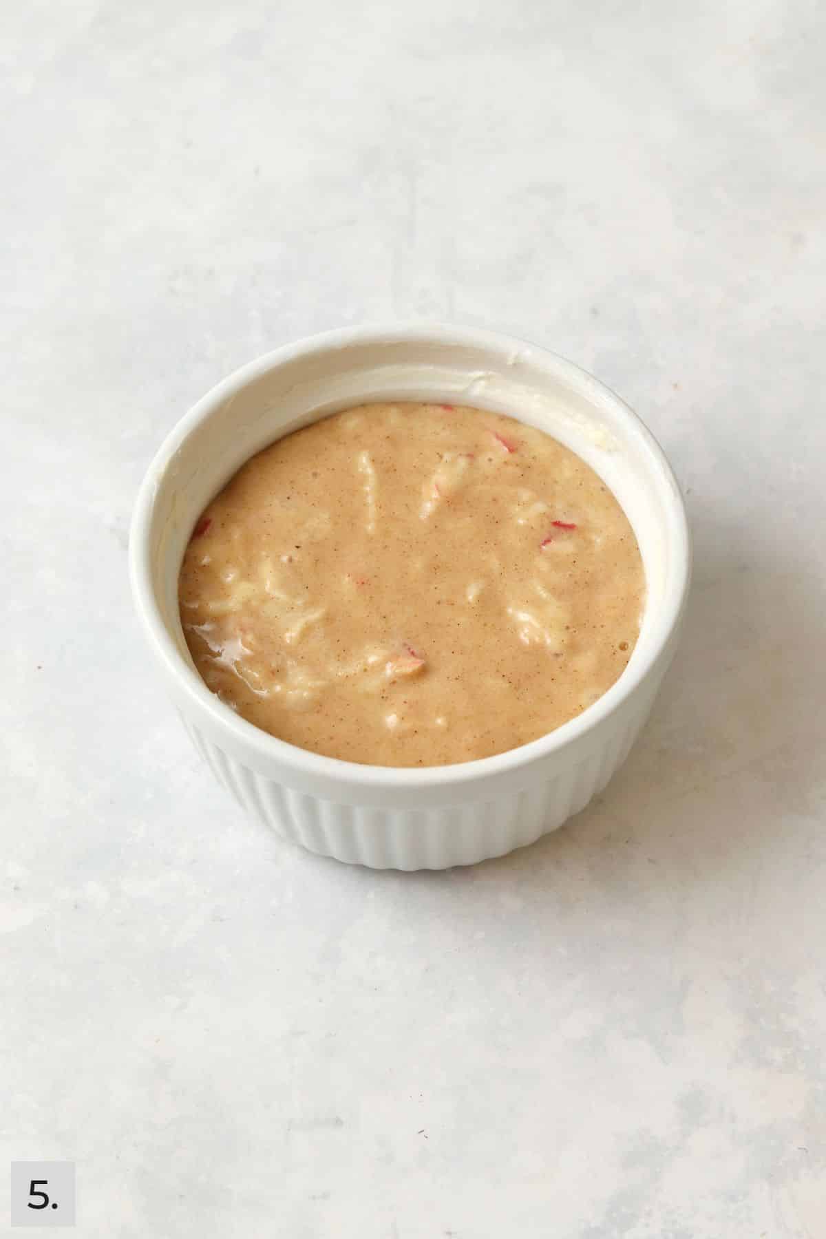 Unbaked single serve apple cake in a ramekin.