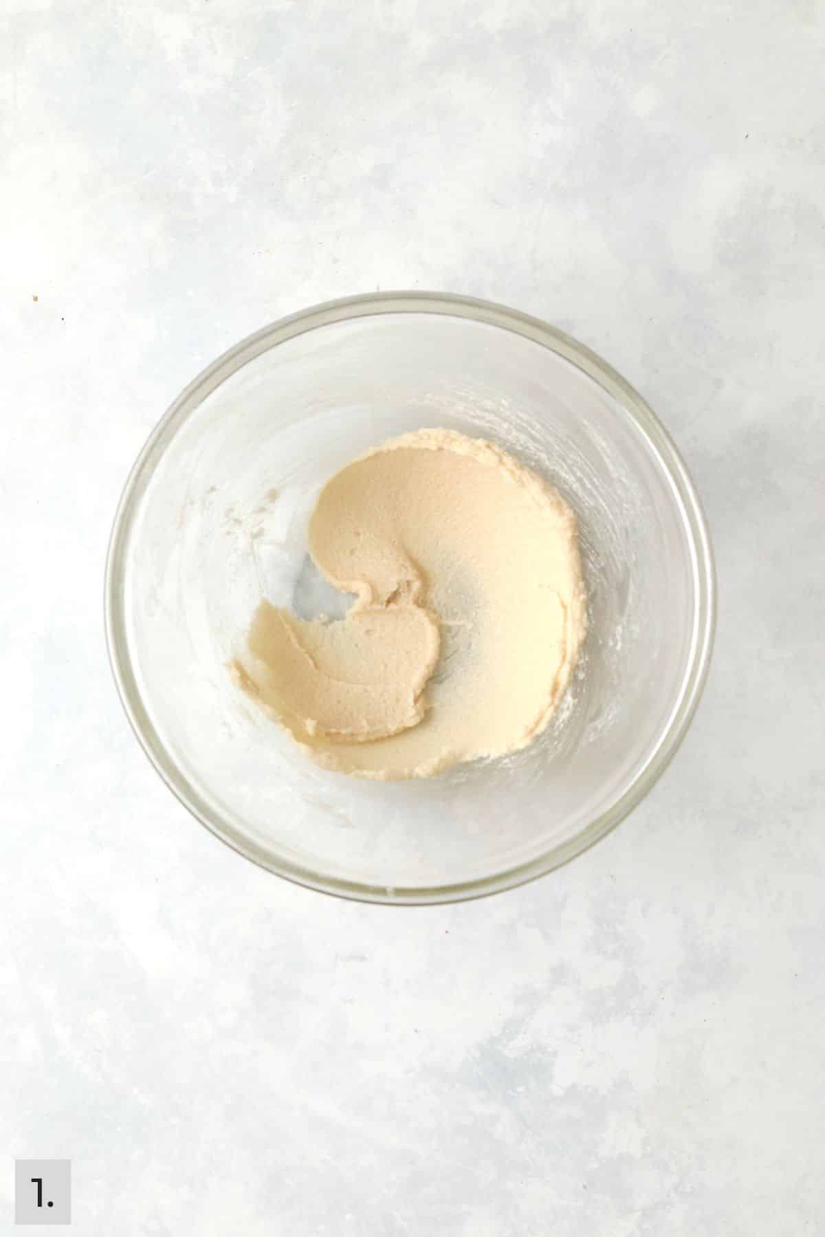 Butter and sugar creamed in a glass bowl.