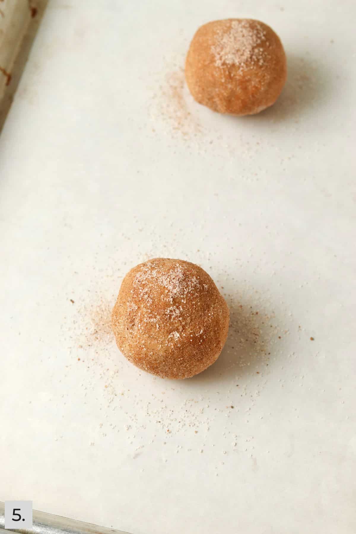 Unbaked chai spiced cookie dough balls on a baking sheet.