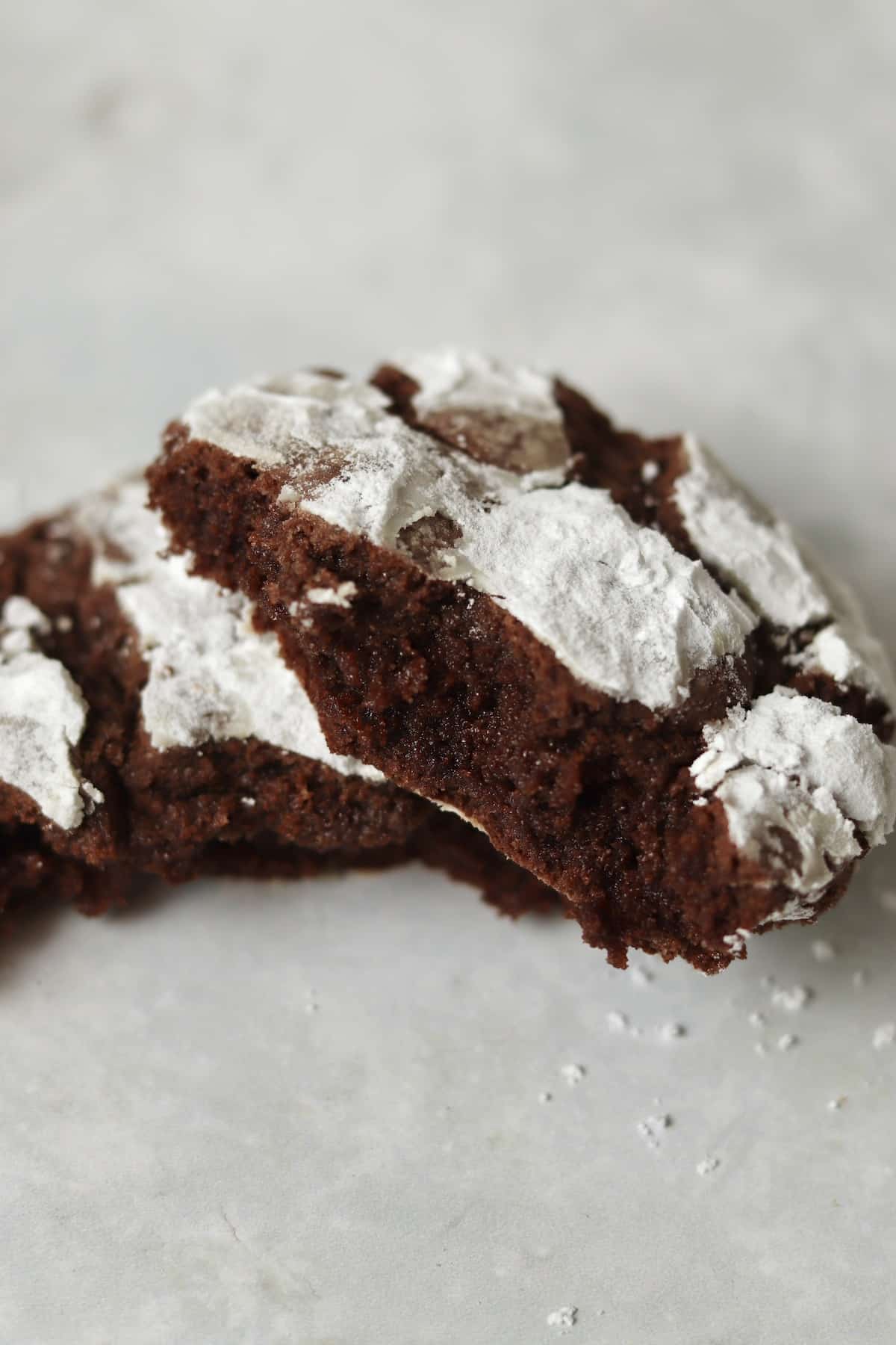 Chocolate crinkle cookie broken in half to show tender and chewy center.