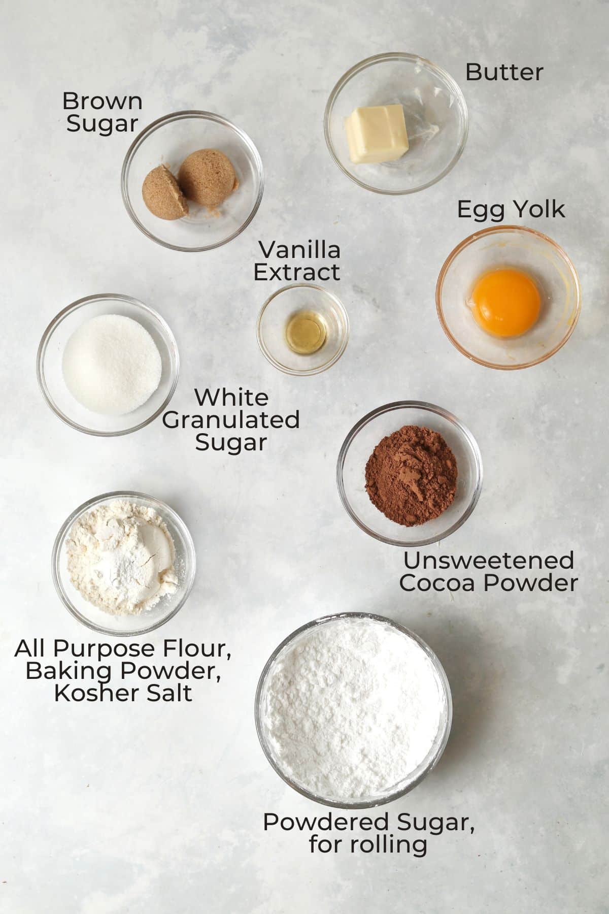 Ingredients to make chocolate crinkle cookies in small glass prep bowls.