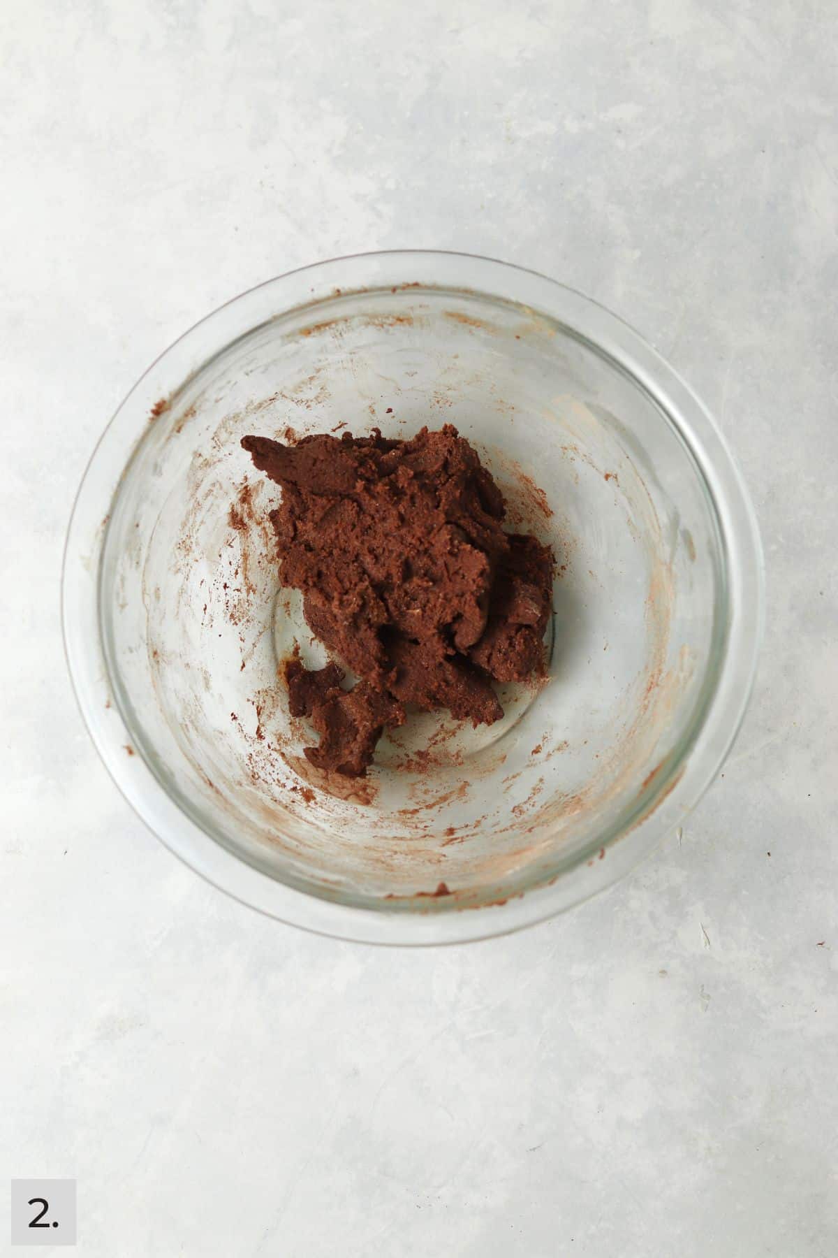 Chocolate cookie dough in a small glass mixing bowl.
