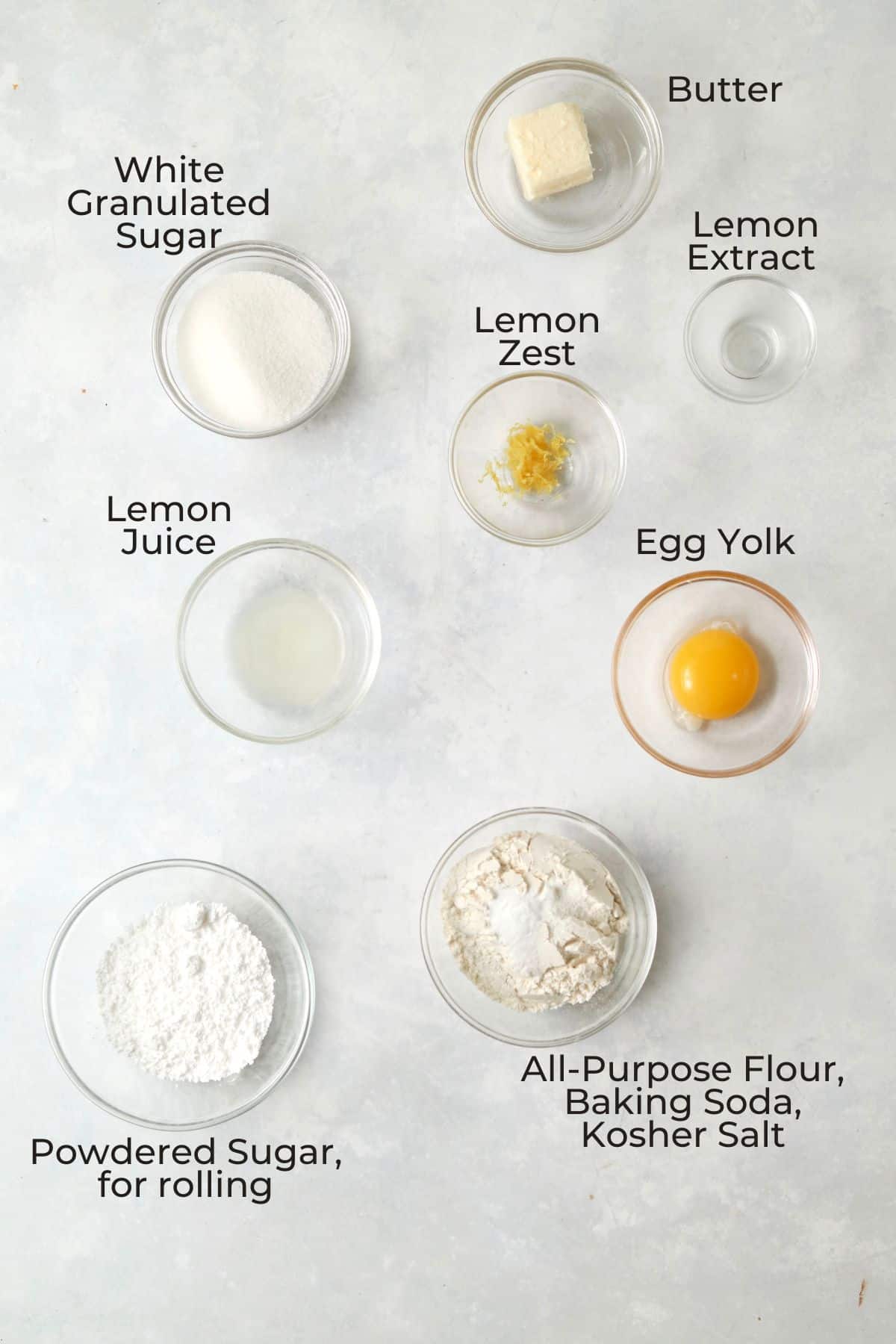 Ingredients to make a single serve lemon crinkle cookie in small glass prep bowls.