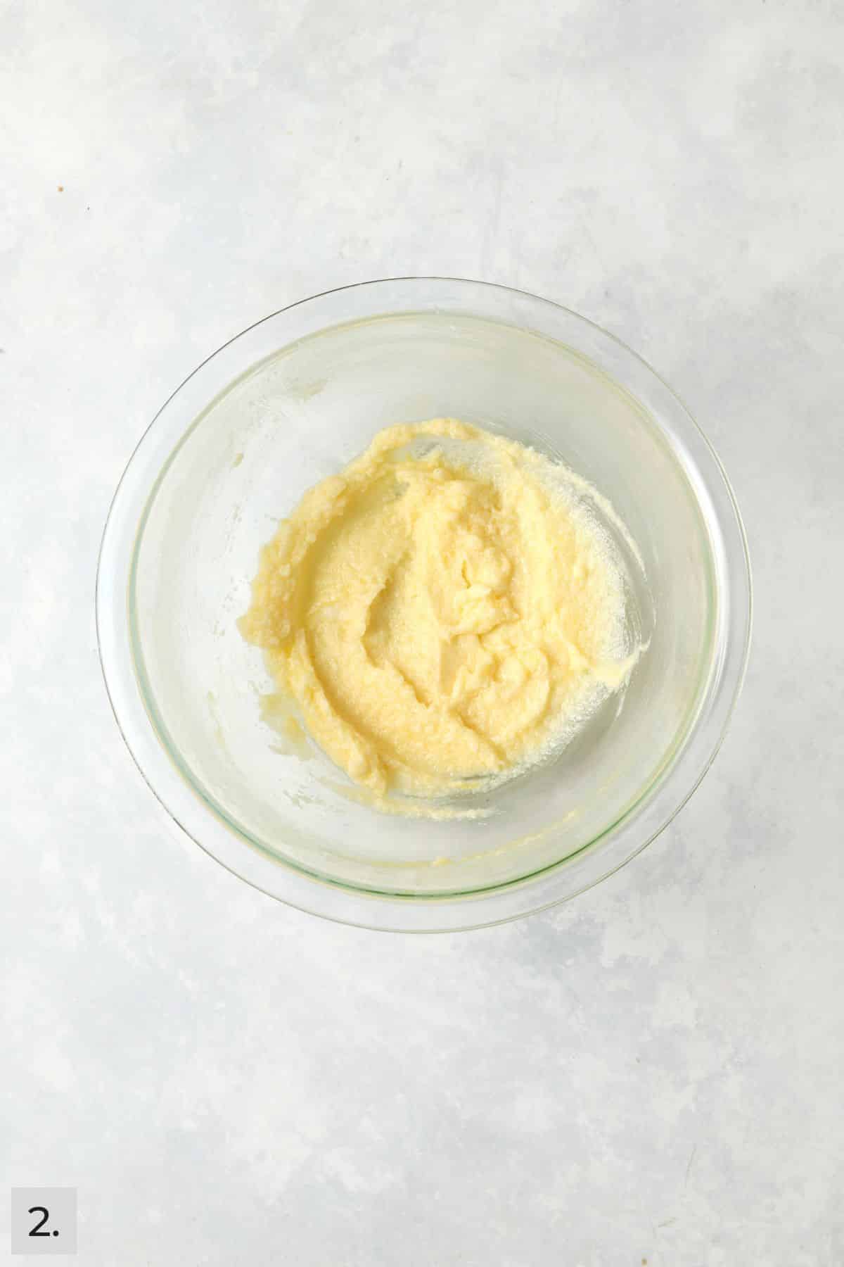 Butter, sugar, egg yolk, and lemon creamed together in a a bowl.