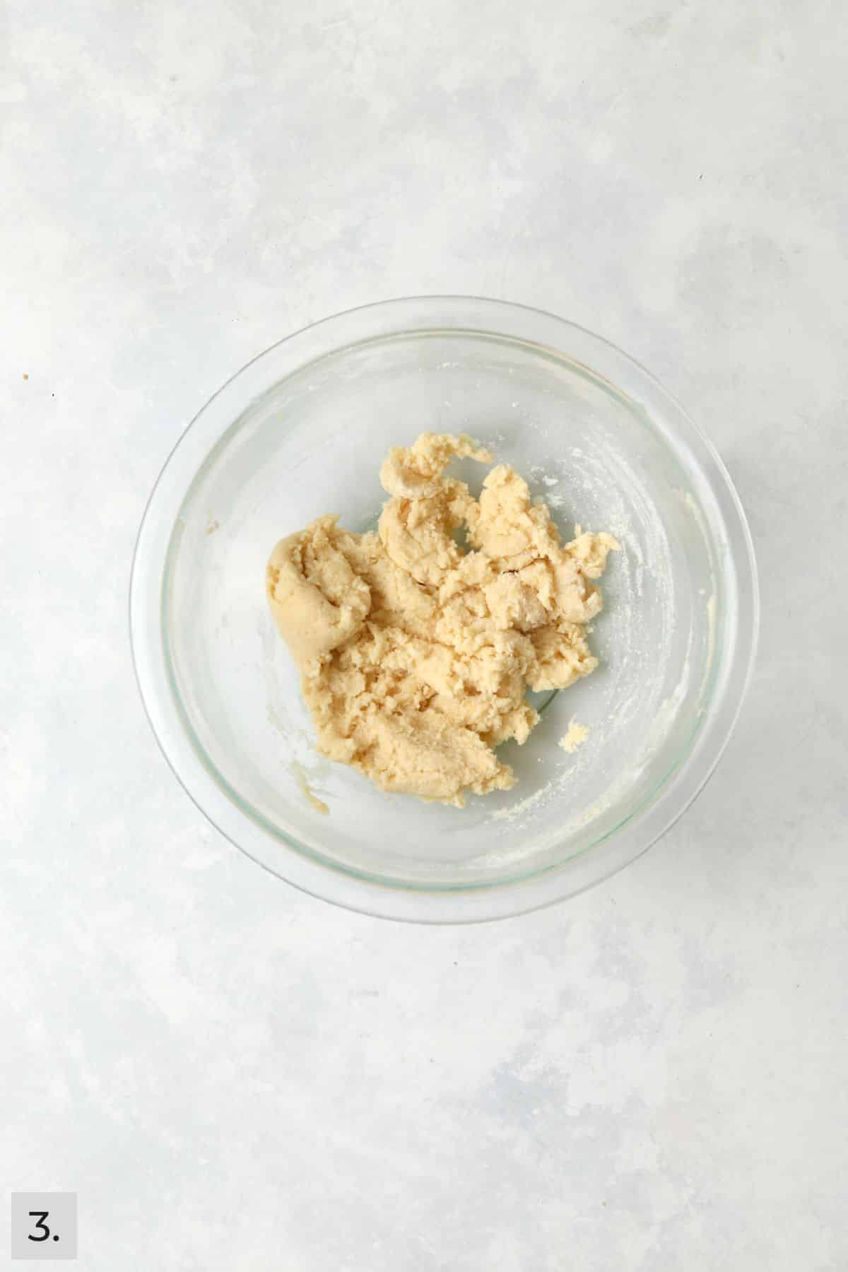 Lemon crinkle cookie dough in a mixing bowl.
