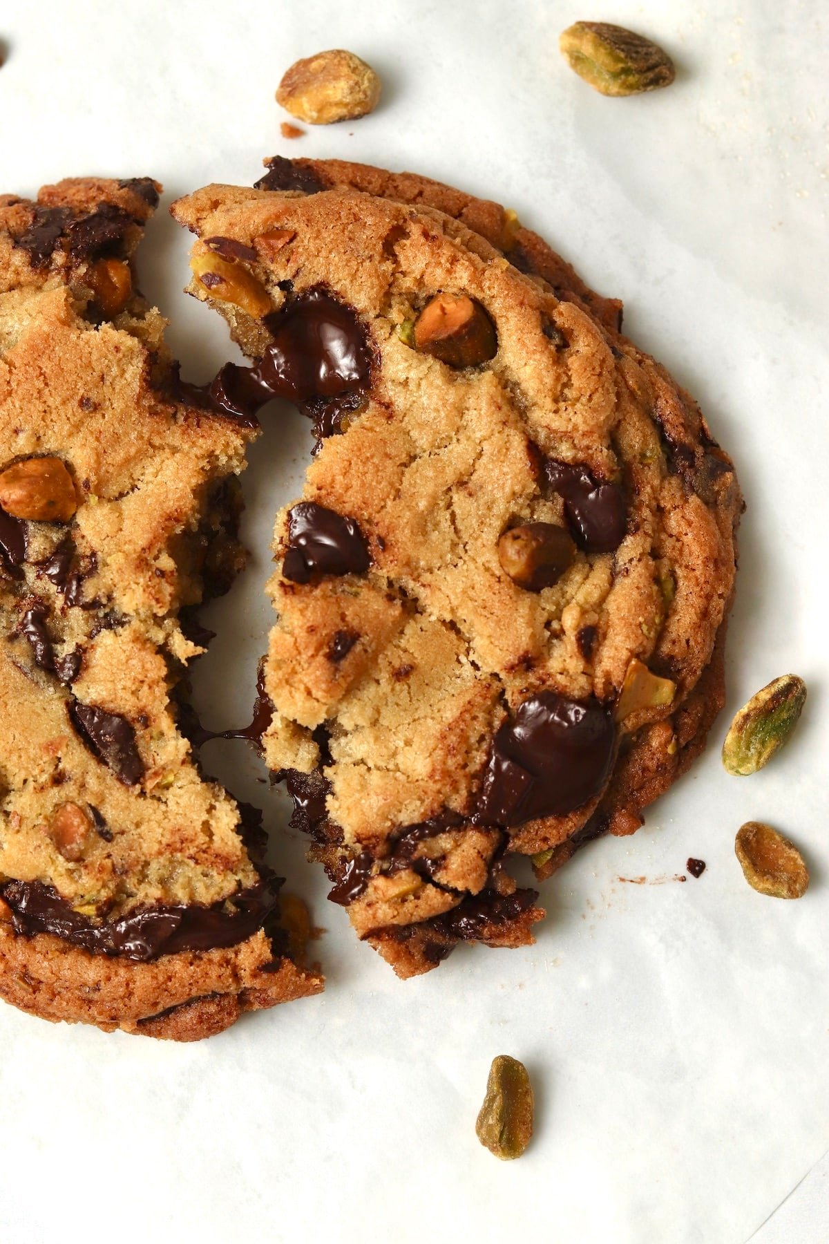 Single serve pistachio chocolate chunk cookie broken in half.