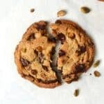 Single serve pistachio chocolate chunk cookie broken in half.